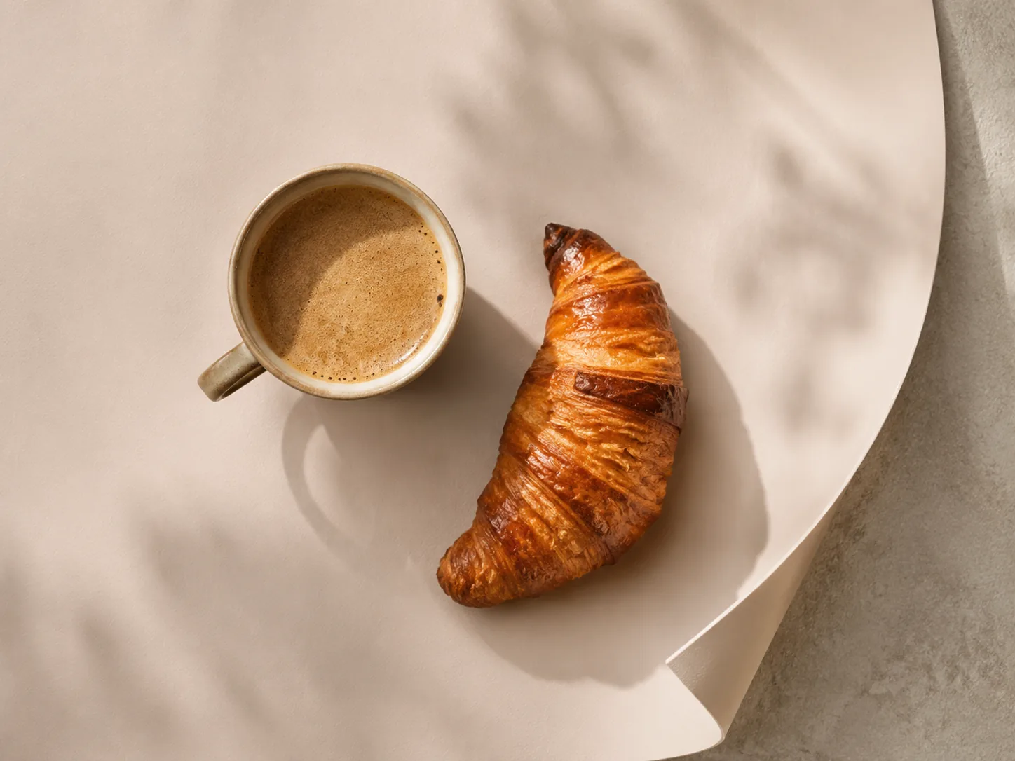 Vue de dessus sur papier effet peau pastel avec café et croissant