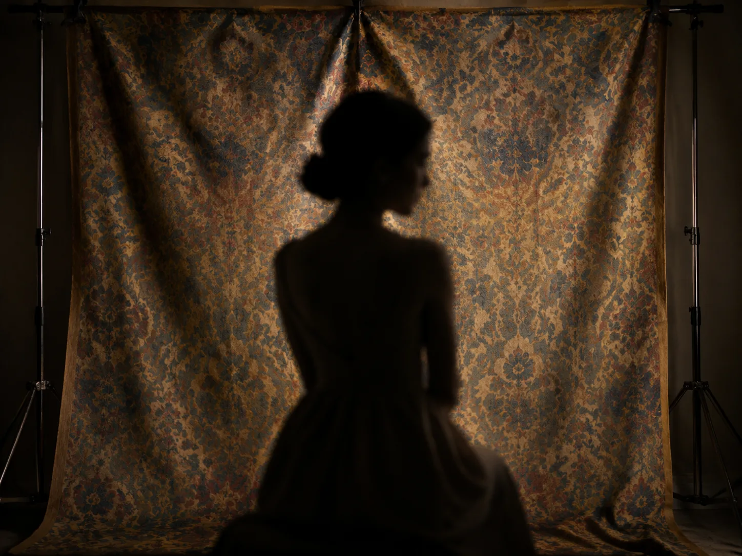 Vintage patterned fabric backdrop hanging in a portrait studio